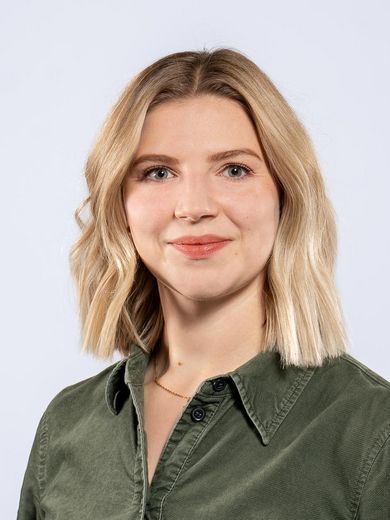 Auf dem Foto ist Annina Drewes zusehen. Sie hat schulterlanges blondes Haar und tr&auml;gt ein gr&uuml;nes Kordkleid. 