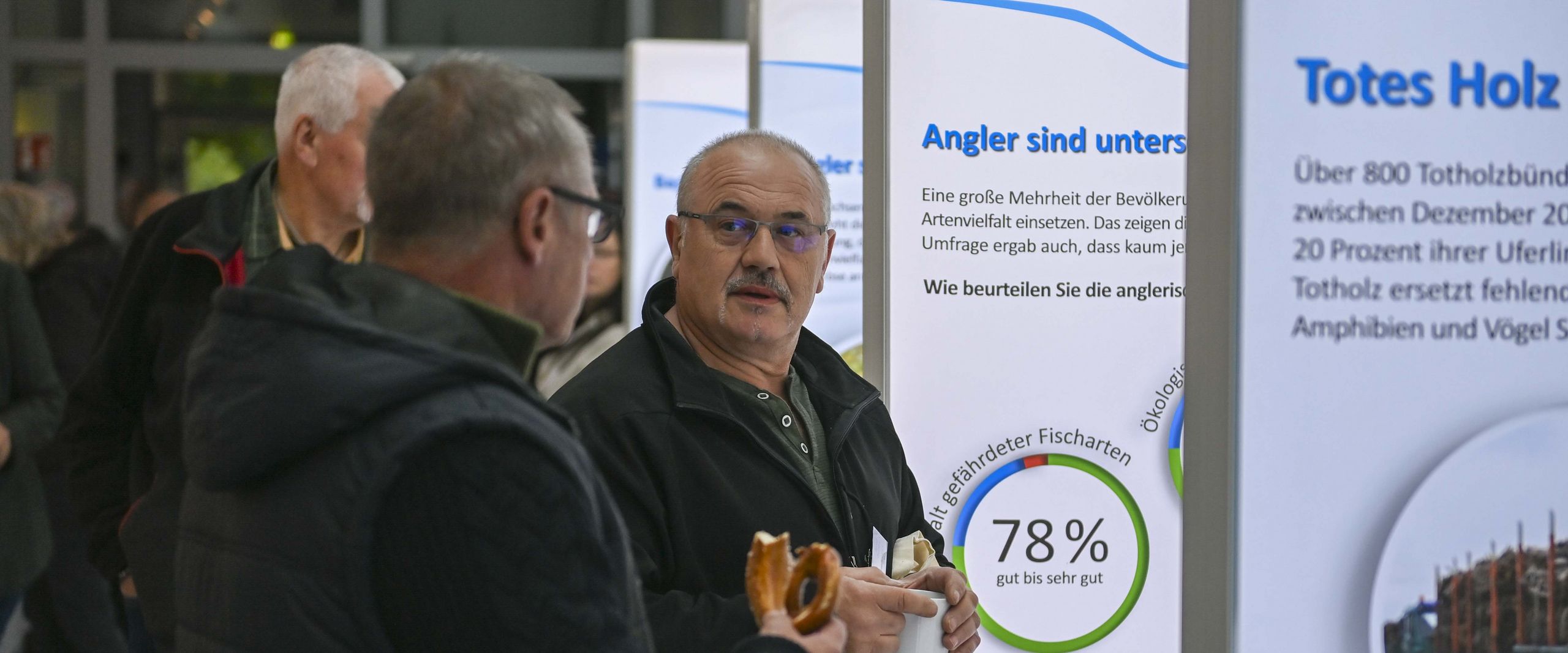 M&auml;nner stehen vor Ausstellungsw&auml;nden