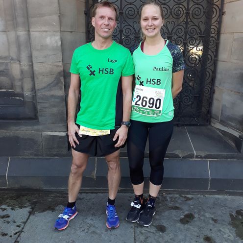 Zwei L&auml;ufer stehen vor einem Geb&auml;ude.