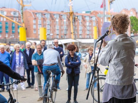 Publikum h&ouml;rt einer Lyrikerin an der Bremer Schlachte zu.