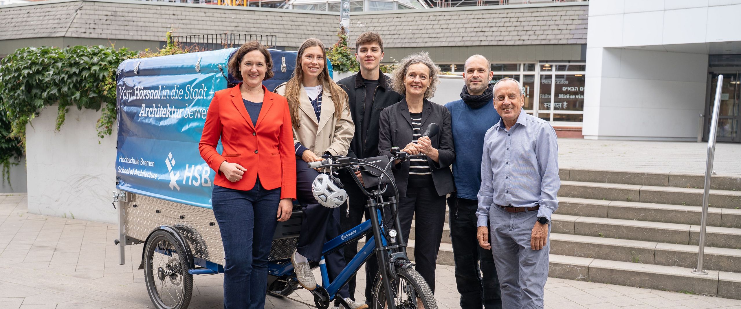 Gruppenbild mit Männern und Frauen vor einem Lastenfahrrad. 