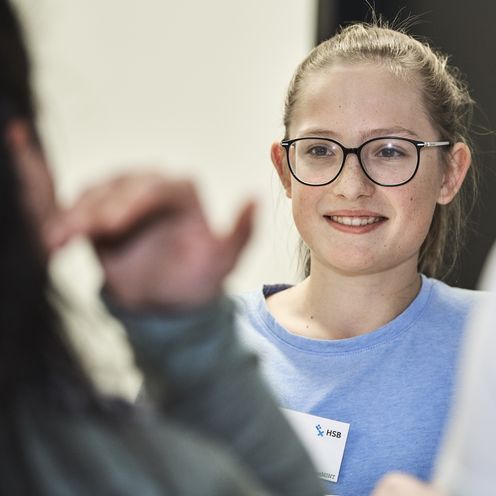Schülerin im Gespräch mit zwei Studentinnen