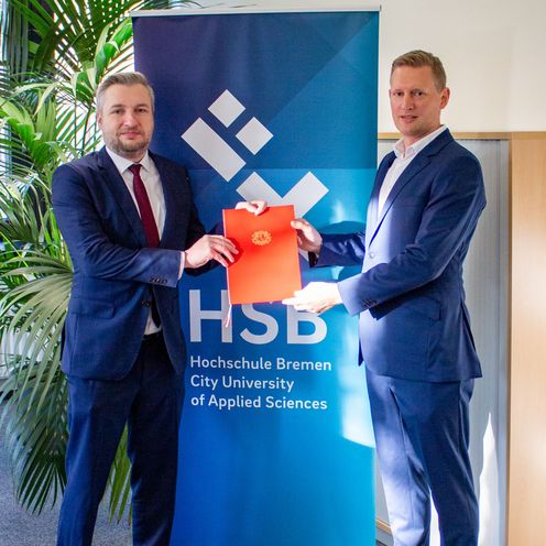 Kanzler Daniel Engelbrecht &uuml;berreicht Professor Heiko Spekker seine Ernennungsurkunde.