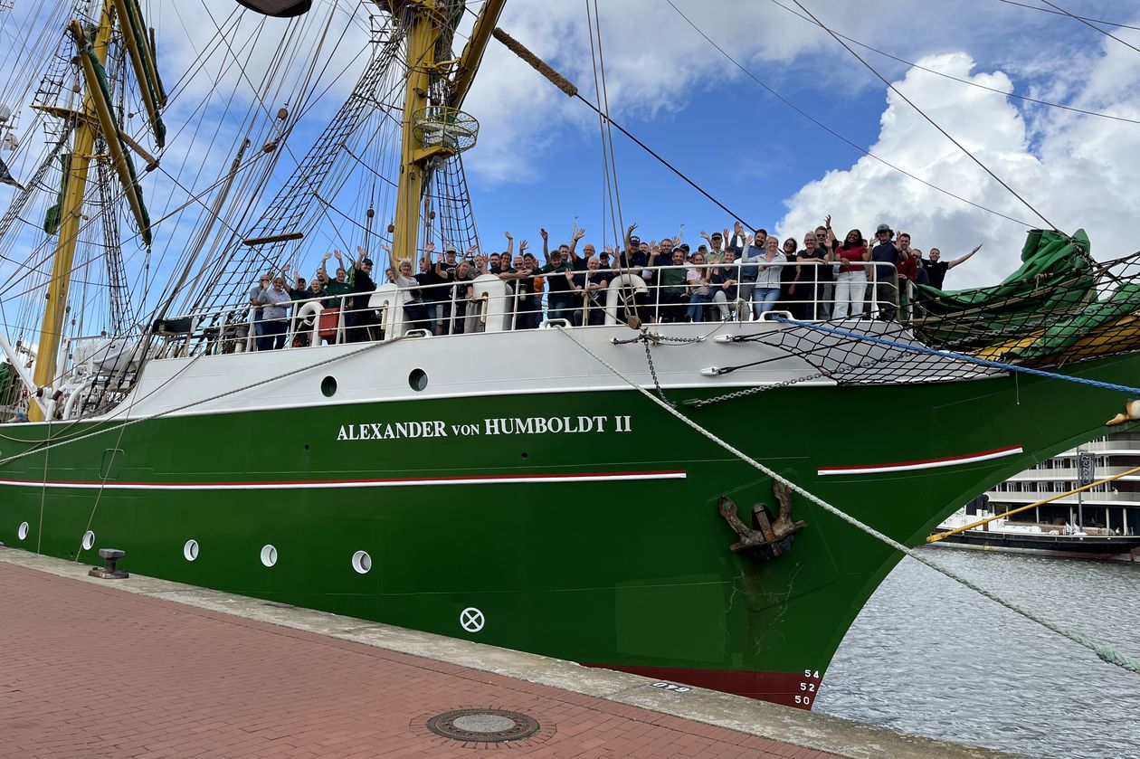 20260817 Alex-2 legt ab Segelschiff it grünem Rumpf. An Bord an der Spitze stehen Menschen und winken