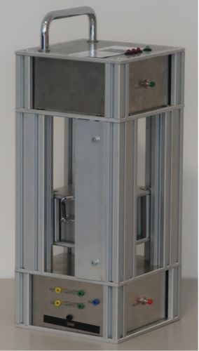 Fahrstuhlmodell Das Bild zeigt ein Modell von einem Fahrstuhl. Es ist ein rechteckiger, silberfarbener Kasten mit diversen Knöpfen in verschiedenen Farben. Im Zentrum des silbernen Kasten ist ein Element, dass hoch und runterfahren kann.