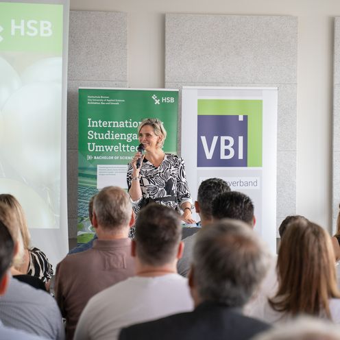 Vor vollen R&auml;ngen begr&uuml;&szlig;te Prof. Ulrike Mansfeld, Dekanin der Fakult&auml;t Architektur, Bau und Umwelt, die Absolvent:innen mit ihren Angeh&ouml;rigen im Staffelgeschoss der Hochschule Bremen zur Absolvent:innenfeier. Foto: HSB / Louisa Windbrake