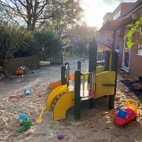 Spielplatz einer KiTa mit Rutsche und Sandkasten