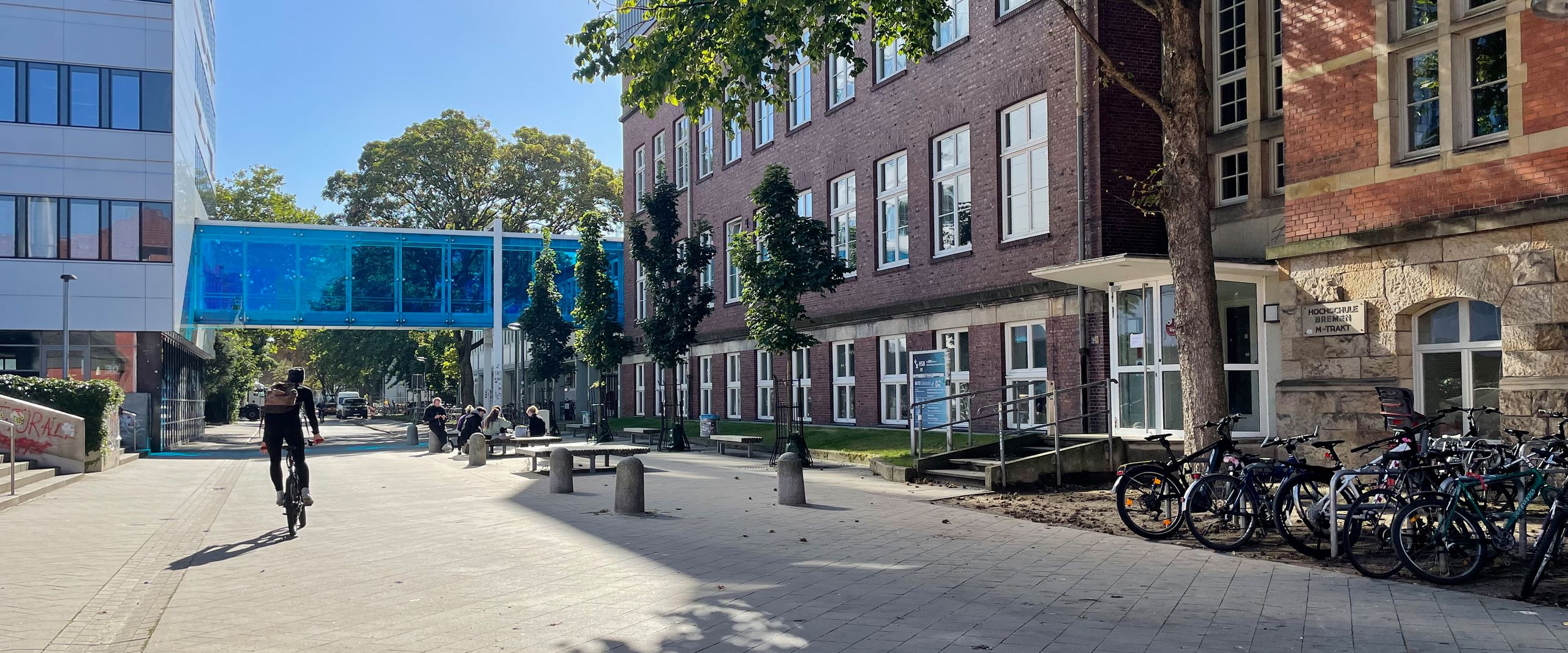 Illustration Projekt BreGoS Gebäude und Staße mit Übergang. Radfahrer und Fußgänger sind zu sehen.