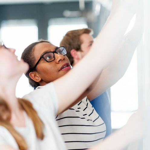 Studienrende h&auml;ngen Pl&auml;ne f&uuml;r eine Pr&auml;sentationa auf. Foto: HSB