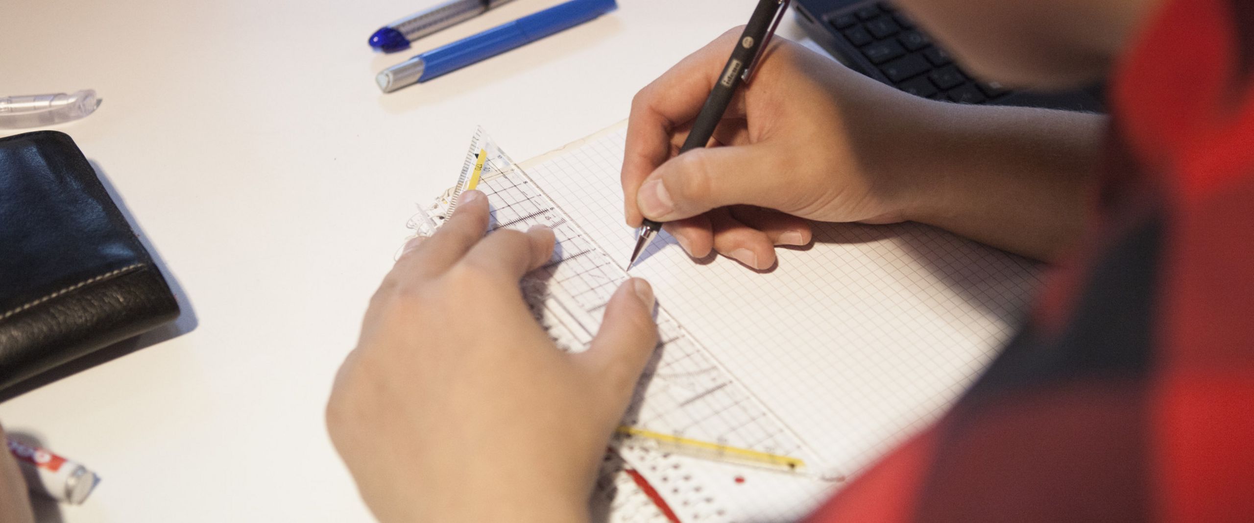 Ein Studierender zeichnet mit einem Geodreieck.