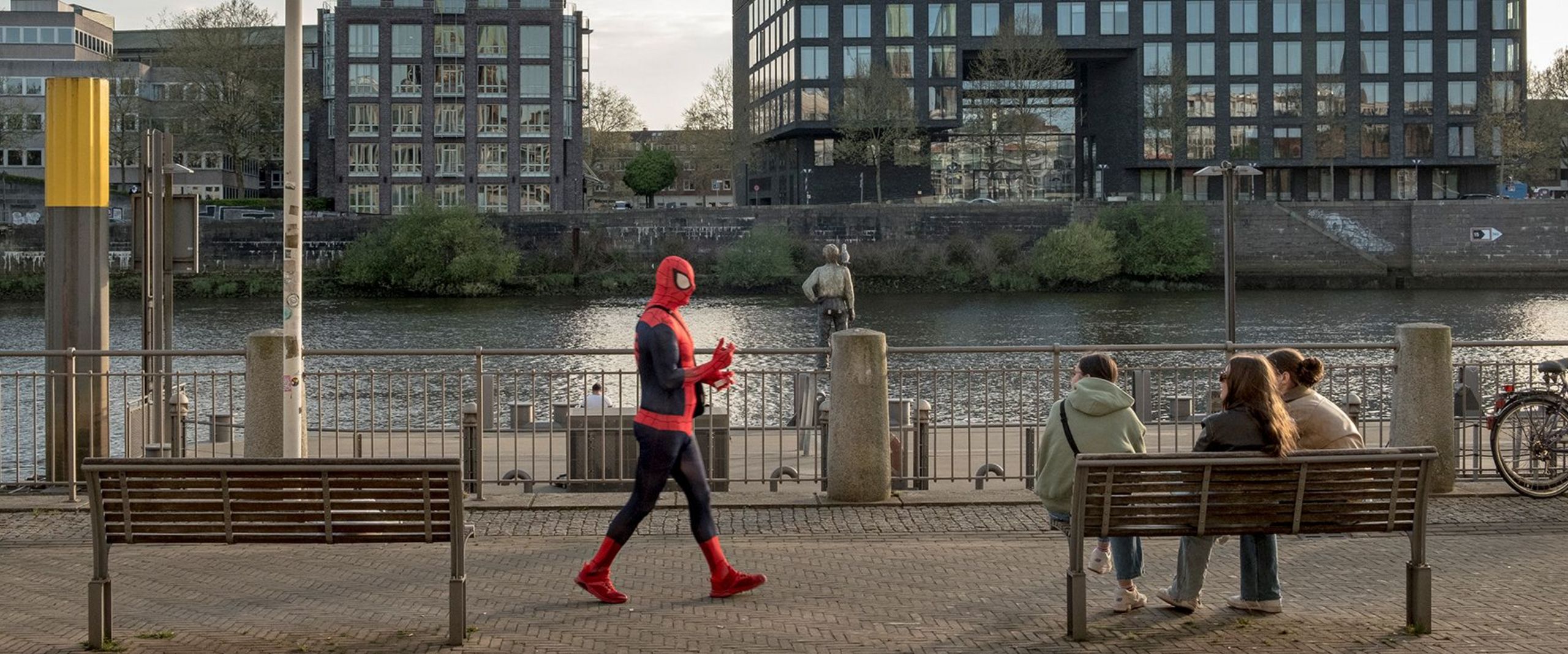 Mann im Spider-Man-Kostüm läuft an der Weserpromenade in Bremen entlang.