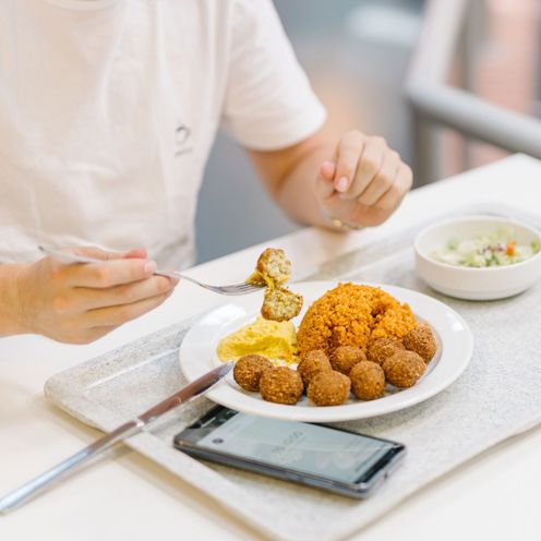 Ein Mann isst in der Mensa zu Mittag.