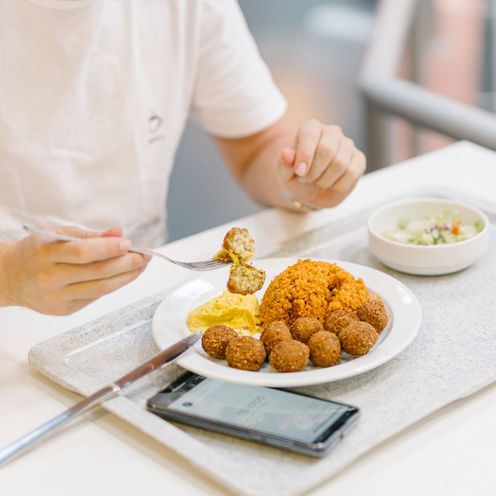 Ein Mann isst in der Mensa zu Mittag.