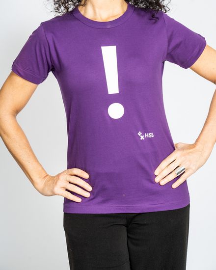 Das Model trägt ein violettes Damen-T-Shirt mit der Aufschrift “!“.