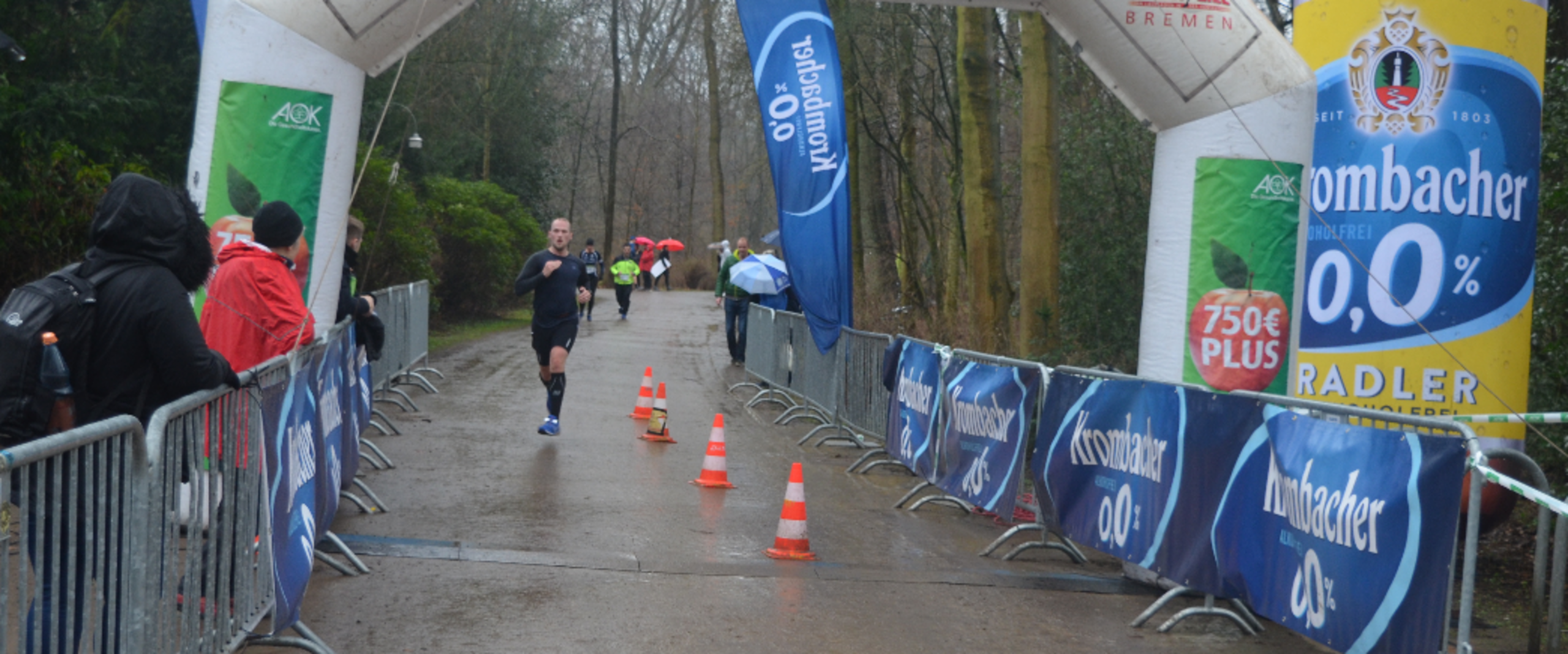Die Ziellinie im Vordergrund und es ist ein L&auml;ufer im Hintergrund zu sehen.