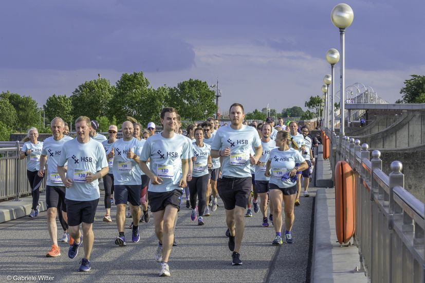 Männer und Frauen joggen auf einer Brücke