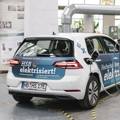 Ein Elektroauto im Branding der Hochschule Bremen wird aufgeladen.