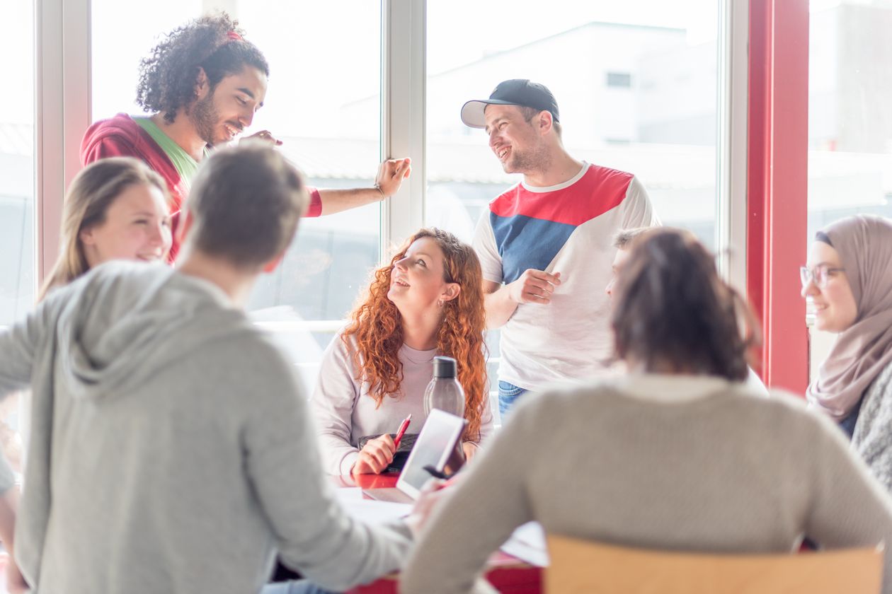 Gruppe von Studierenden Eine Gruppe von Studierenden unterhält sich, einige stehen, andere sitzen.