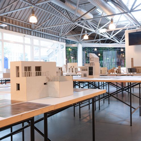 Blick auf eine Ausstellung mit Architekturmodellen auf Tischen