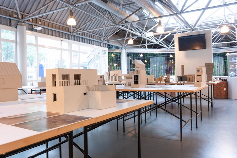 Blick auf eine Ausstellung mit Architekturmodellen auf Tischen