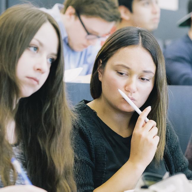 Studierende sitzen nebeneinander in einem Hörsaal.