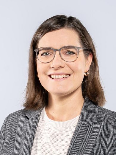 Auf dem Foto ist Leena Pundt zusehen. Sie hat schulterlanges braunes Haar. Sie tr&auml;gt eine Brille und einen grauen Blazer &uuml;ber einem wei&szlig;en Shirt. 