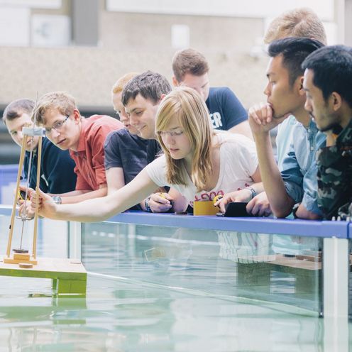 Studierende testen eine schwimmende Konstruktion in einem Wasserbecken.