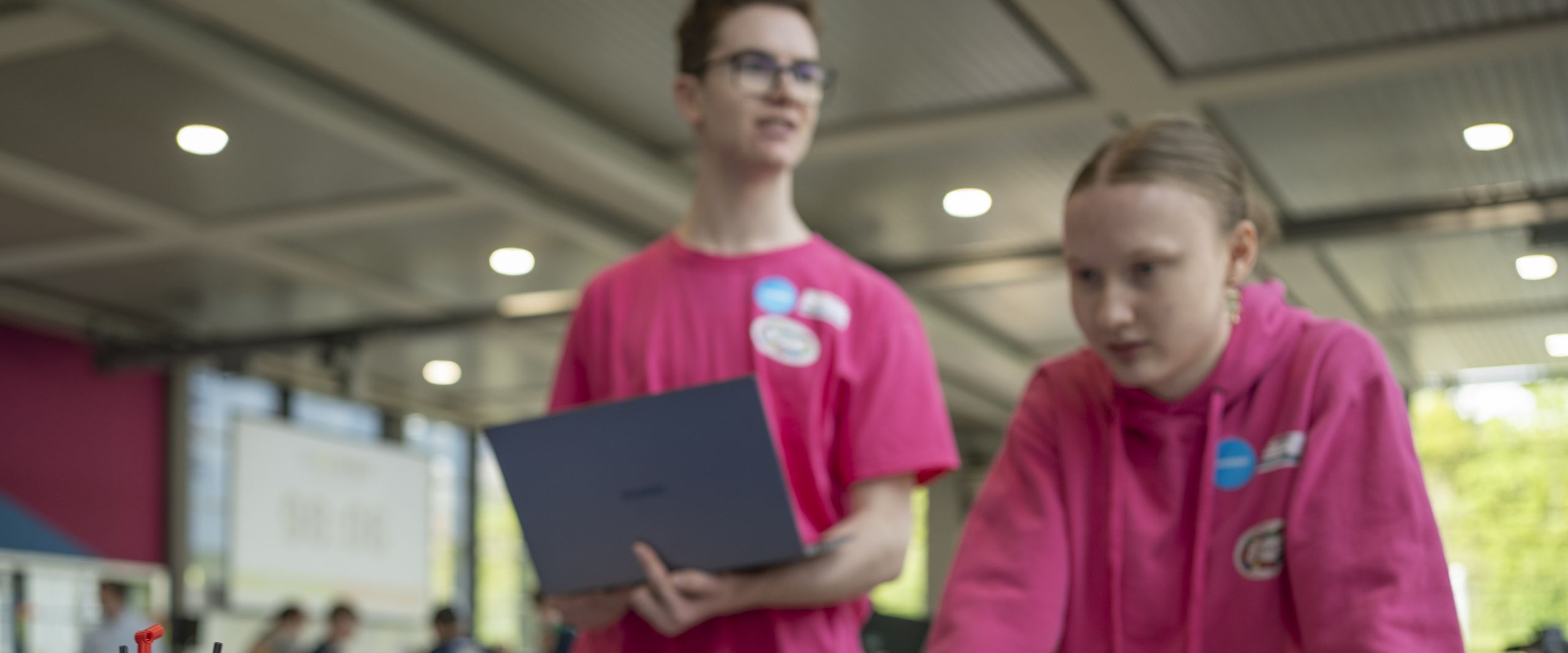Zwei Personen steuern einen Roboter aus Klemmbausteinen 