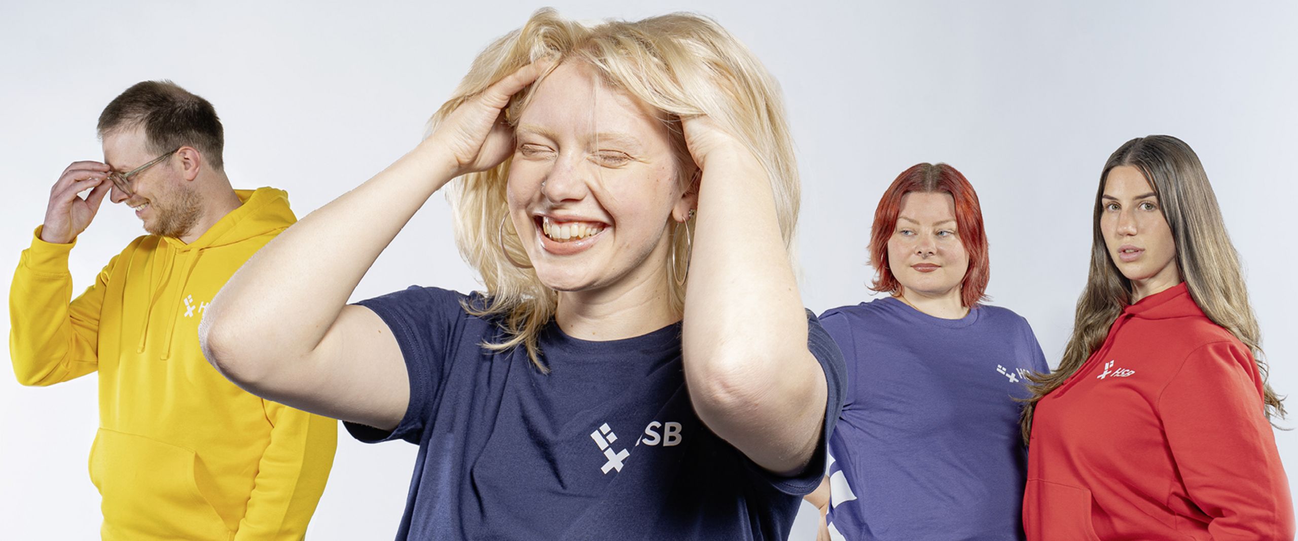Studierende in HSB-Merchandise Eine Gruppe Studierende, die T-Shirts und Hoodies in verschiedenen Farben mit HSB-Logo trägt-