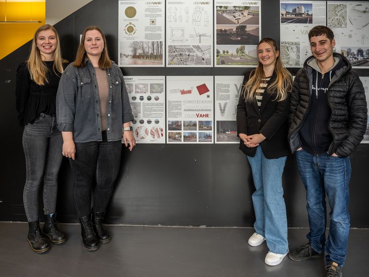 Gruppenbild mit jungen Männern und Frauen vor Postern