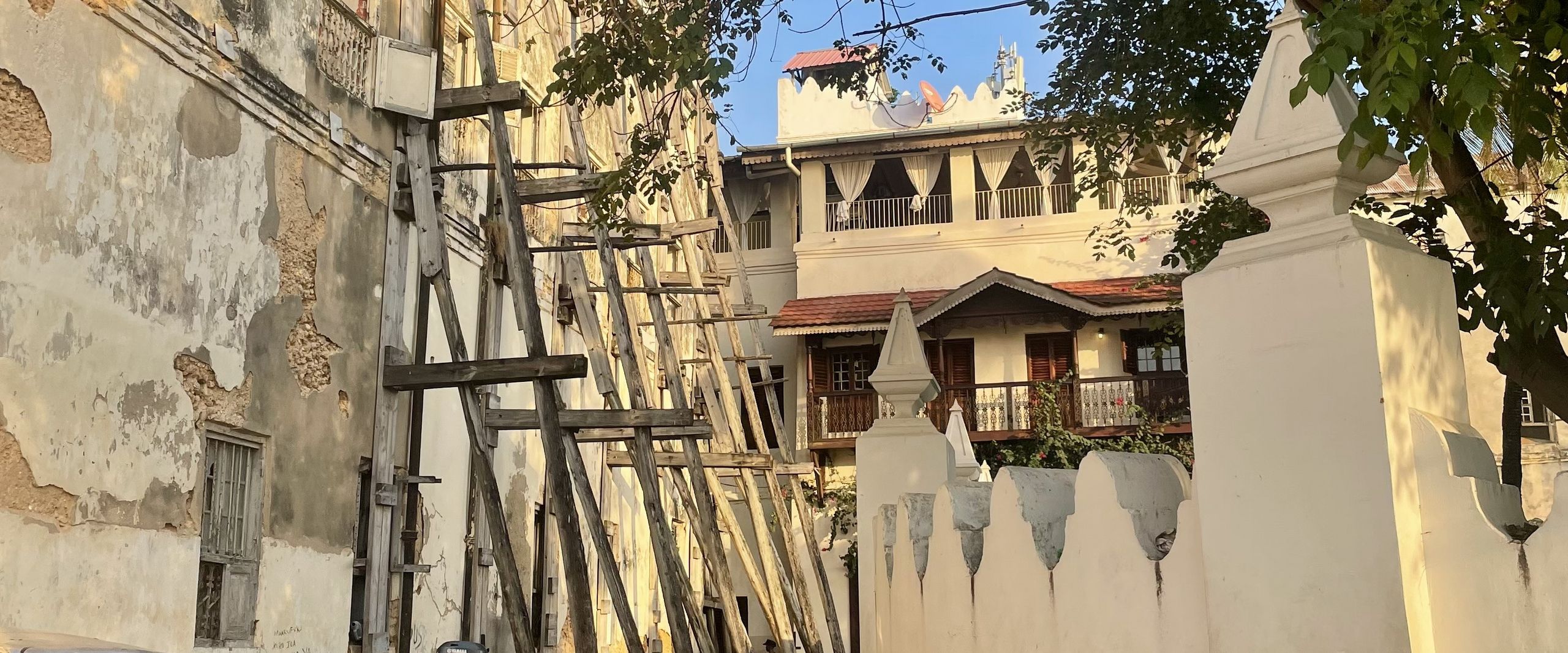 Steinh&auml;user, die zum Teil von Holzpf&auml;hlen gest&uuml;tzt werden 