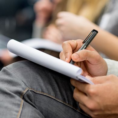 Visum beantragen Bild zeigt jemanden, der auf Schreibblock schreibt