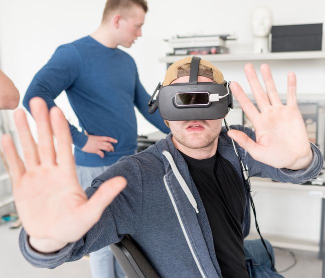 Student mit VR Brille hebt abwehrend die H&auml;nde hoch