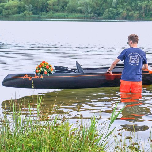Jungfernfahrt Tretboots Reignbow, das Boot wird von 3 Studierenden zu Wasser gelassen.