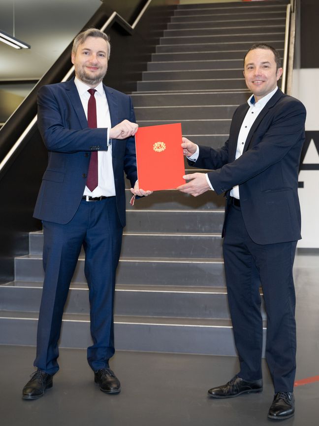 Kanzler Daniel Engelbrecht überreicht Prof. Fürstenberg seine Ernennungsurkunde zum Professor.