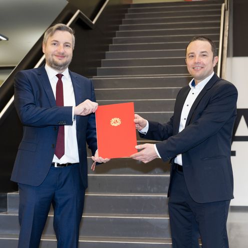 Kanzler Daniel Engelbrecht &uuml;berreicht Prof. F&uuml;rstenberg seine Ernennungsurkunde zum Professor.