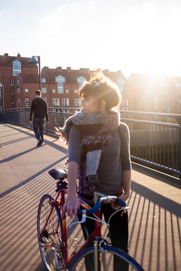 Eine Studentin schiebt ihr Fahrrad.