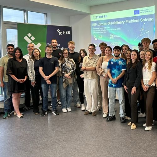 Gruppenbild mit 34 Personen. Im Hintergrund eine Projektion mit Stars EU Logo.