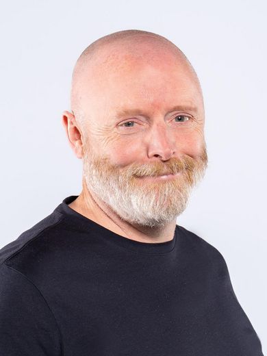 Auf dem Foto ist Peter Gough zusehen. Er tr&auml;gt eine Glatze und einen grau orangen Bart und ein dunkelblaues T-Shirt. 