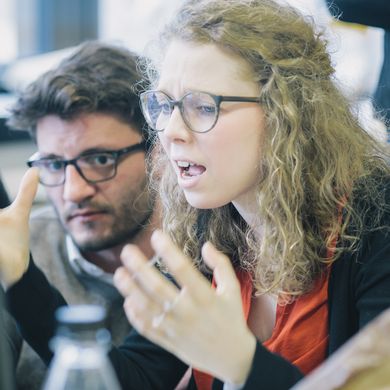 Junge Frau hebt zweifelnd die H&auml;nde.