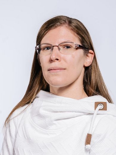 Auf dem Bild ist Jennifer Friederichs zusehen. Sie hat langes glattes Haar und trägt eine schwarze Brille und einen weißen Pullover. 