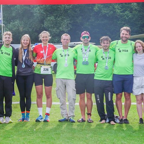 Das Team HSB_TriRunners Team vor der Zielmarkierung des Müritz Triathlons.