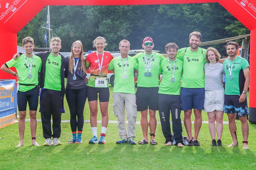 Das Team HSB_TriRunners Team vor der Zielmarkierung des Müritz Triathlons.