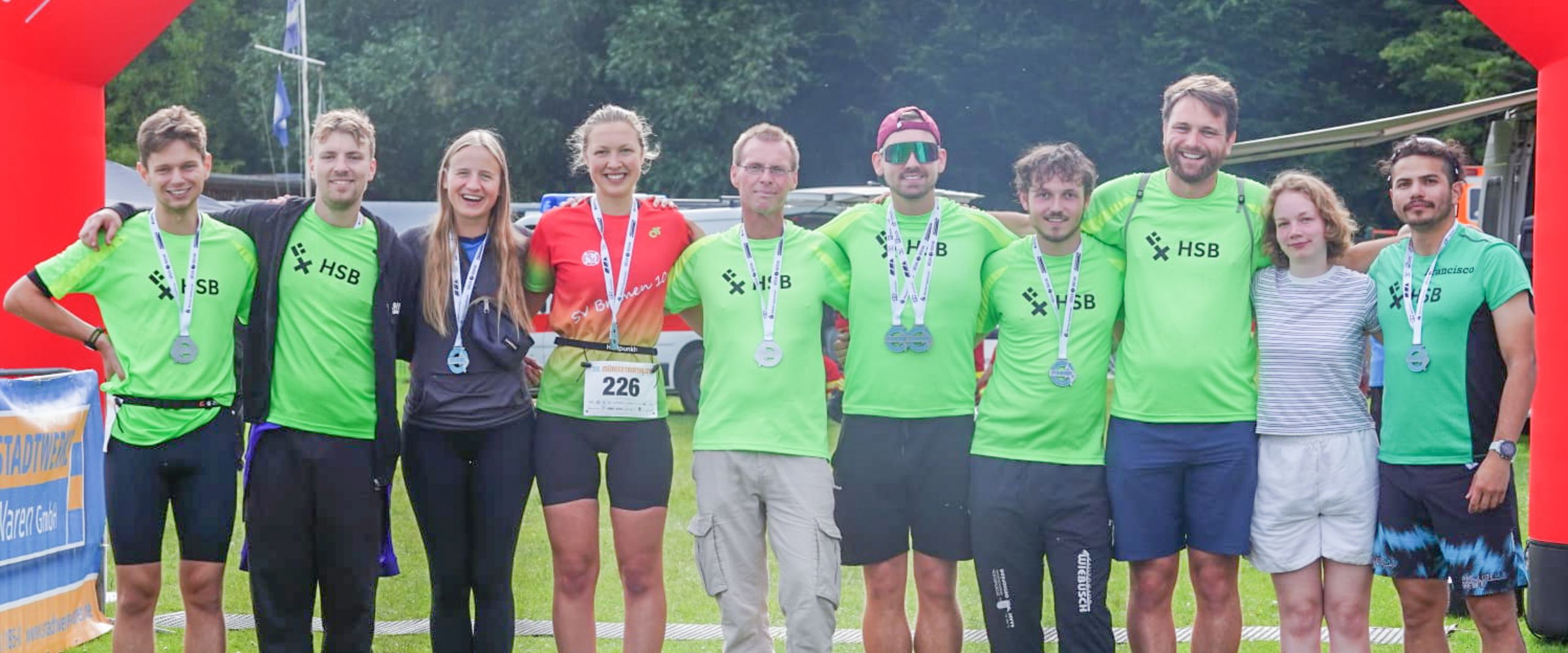 Das Team HSB_TriRunners Team vor der Zielmarkierung des Müritz Triathlons.