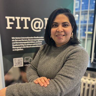 Portait einer Frau. Im Hintergrund sieht man ein Roll-up