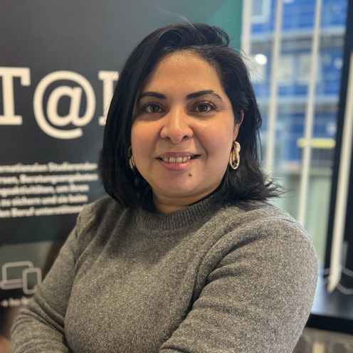 Portait einer Frau. Im Hintergrund sieht man ein Roll-up