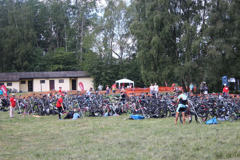 Diverse Fahrr&auml;der und L&auml;ufer stehen auf einer Wiese.