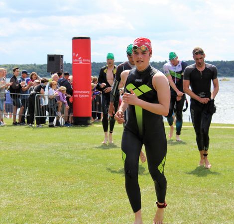 Schwimmer:innen in Neoprenanz&uuml;gen laufen beim M&uuml;ritz-Triathlon 2021 ans Ufer.