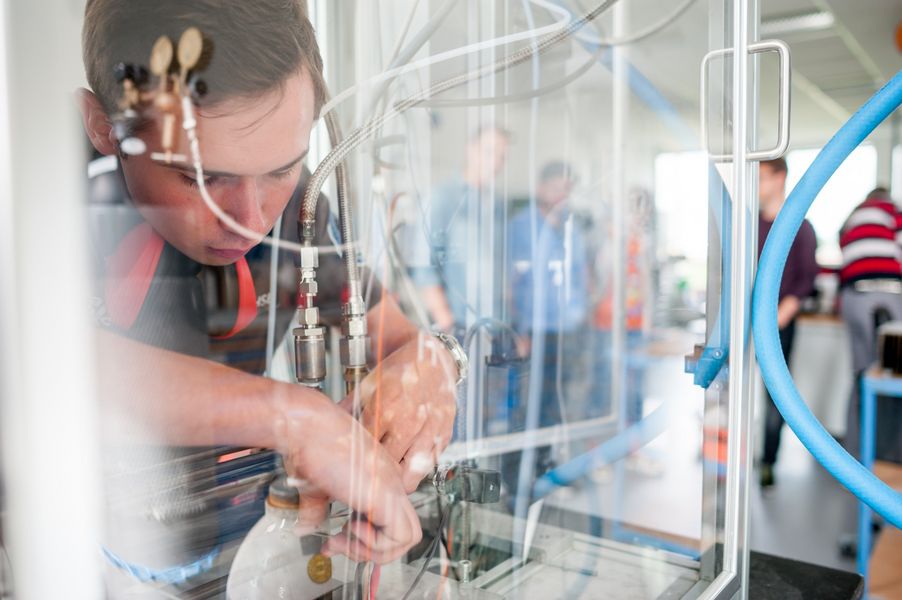Laborversuch Hybridraketentriebwerk  Ein Labormitarbeiter arbeitet am Versuchsaufbau eines Raketentriebwerks.
