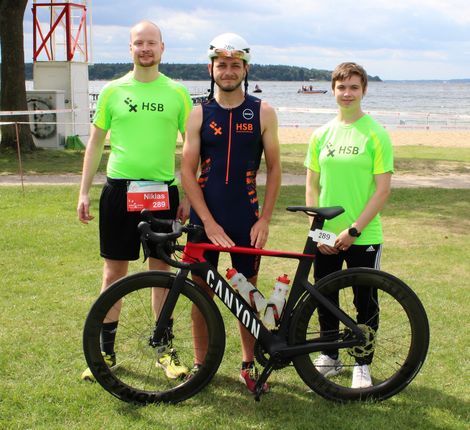 Mitglieder der HSB TriRunners posieren mit einem Rennrad beim M&uuml;ritz-Triathlon 2021.